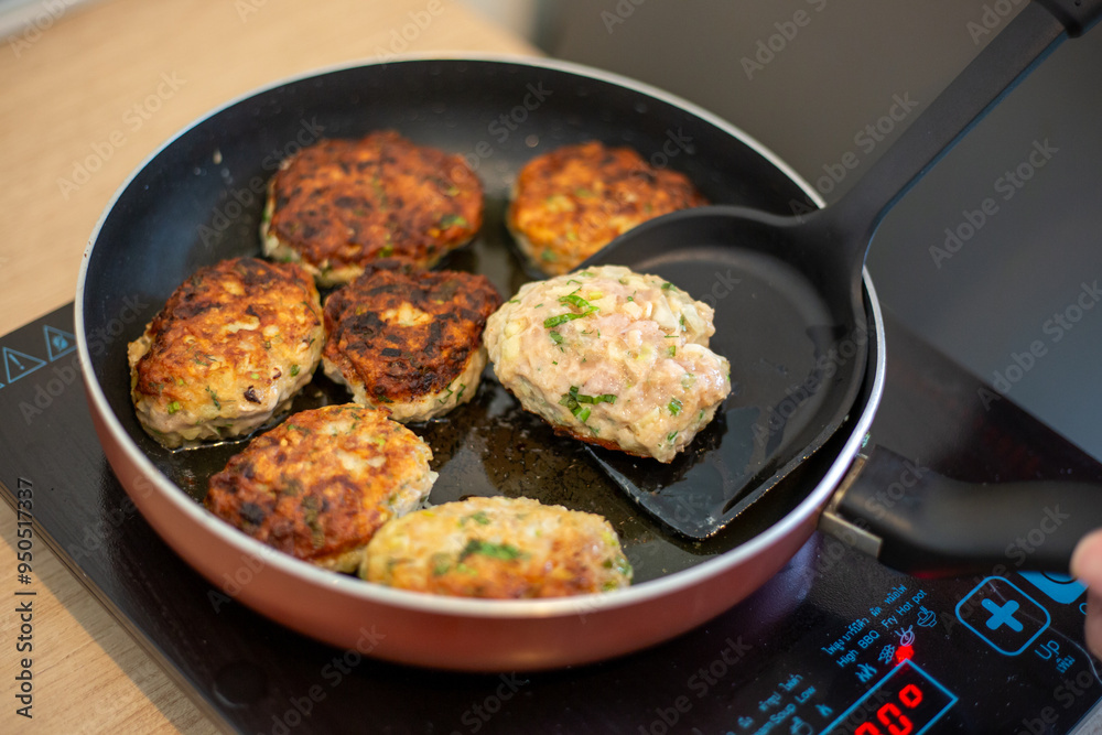 Cooking. The frying pan is on the induction stove, in which meat patties are fried Cooking. The frying pan is on the induction stove, in which meat patties are fried