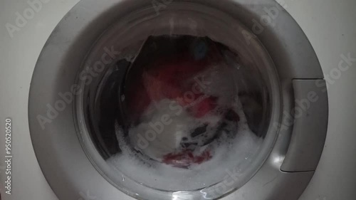 Close-up view of a washing machine drum with soapy water and clothes.