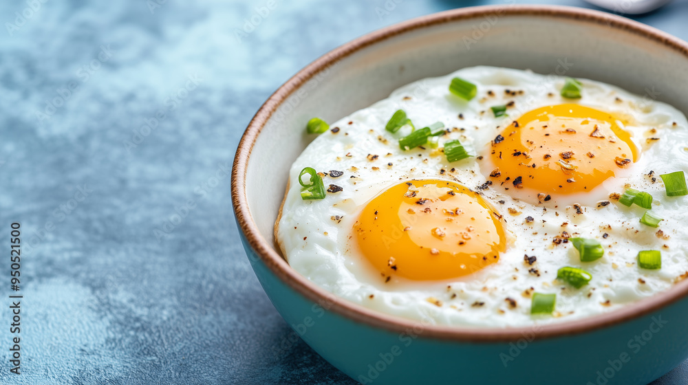 Freshly cooked sunny side up eggs in a bowl with herbs Freshly cooked sunny side up eggs in a bowl with herbs