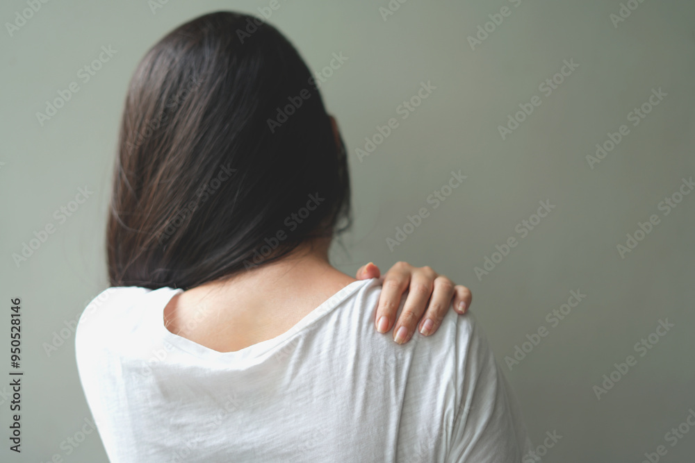 Tired young asian woman suffering neck pain while working for so long at home, exhausted young female rubbing and massaging her painful area and frowning, suffering osteoporosis or arthritis. Tired young asian woman suffering neck pain while working for so long at home, exhausted young female rubbing and massaging her painful area and frowning, suffering osteoporosis or arthritis.