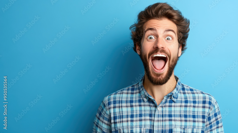 A bearded man in a checkered shirt with a wide-open mouth, expressing excitement and surprise, against a blue background. A bearded man in a checkered shirt with a wide-open mouth, expressing excitement and surprise, against a blue background.