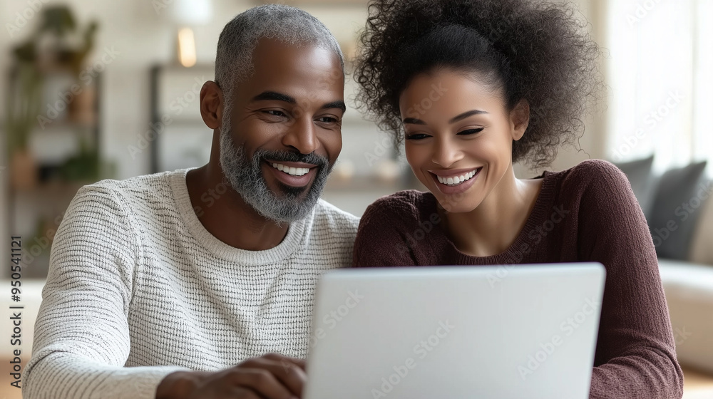 Elegant, attractive couple exchanging glances over a laptop in a cozy bright. Elegant, attractive couple exchanging glances over a laptop in a cozy bright.