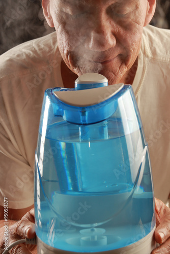 Man using an air humidifier to help him breath in dry weather 

 photo