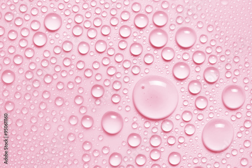 Water drops texture background. Pink toner spray, face mist, serum, liquid skin care product closeup
