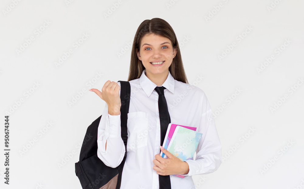 Hey look. Smiling pretty female model pointing fingers left at empty space and inviting to check it out, showing advertisement on white background. Girl with notepads in hands. Hey look. Smiling pretty female model pointing fingers left at empty space and inviting to check it out, showing advertisement on white background. Girl with notepads in hands.