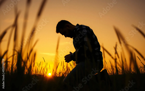 Prayer concept. Silhouette of a man in a praying pose. On his Knees forgiveness. vibrant sunset sunrise sky. Clasped hands lonely. sacrifice, sincerity , sanctification, shepherd, trinity, shadow photo