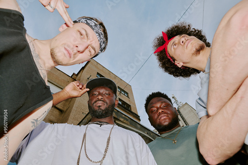 Obraz na plátně Low angle shot of biracial bad boy band dressed in street style clothes looking