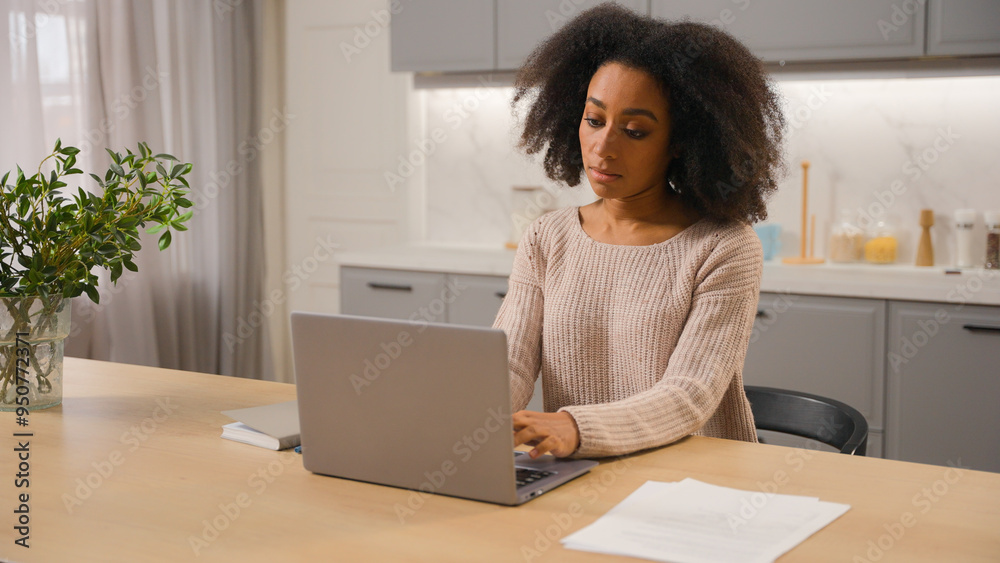 African American woman freelancer online working from home with laptop in kitchen young ethnic girl female businesswoman writer pensive thinking create idea typing article on computer distant studying African American woman freelancer online working from home with laptop in kitchen young ethnic girl female businesswoman writer pensive thinking create idea typing article on computer distant studying