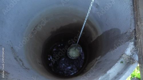Fetching water from well by hand, fresh pure drinking mineral water.