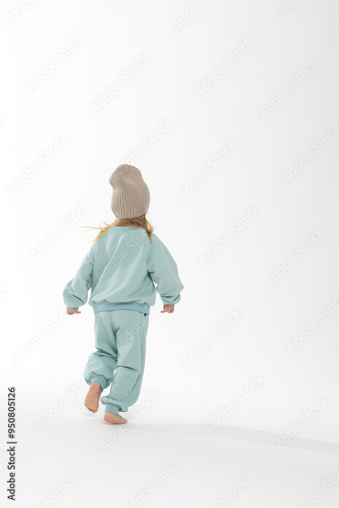 Portrait of beautiful cute little toddler girl. Child with funny face in mint sweatshirt and hat. Pretty smile kid in studio on white background. Portrait of beautiful cute little toddler girl. Child with funny face in mint sweatshirt and hat. Pretty smile kid in studio on white background.