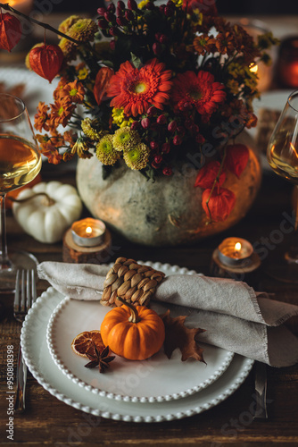 Cozy festive holiday table decor for home family Thanksgiving dinner. Traditional event, elegant natural decoration. Wooden rustic table, countryside style. Burning candles, floral centrepiece pumpkin