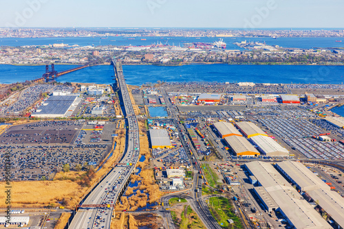 Aerial view of a busy industrial area and bridge over a river in New York City, captured from an airplane window. photo