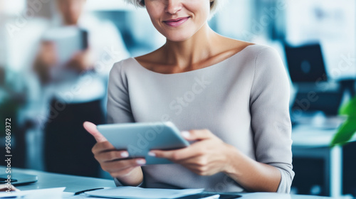 Free Download A woman is holding a tablet in her hand and smiling - GFXLoad