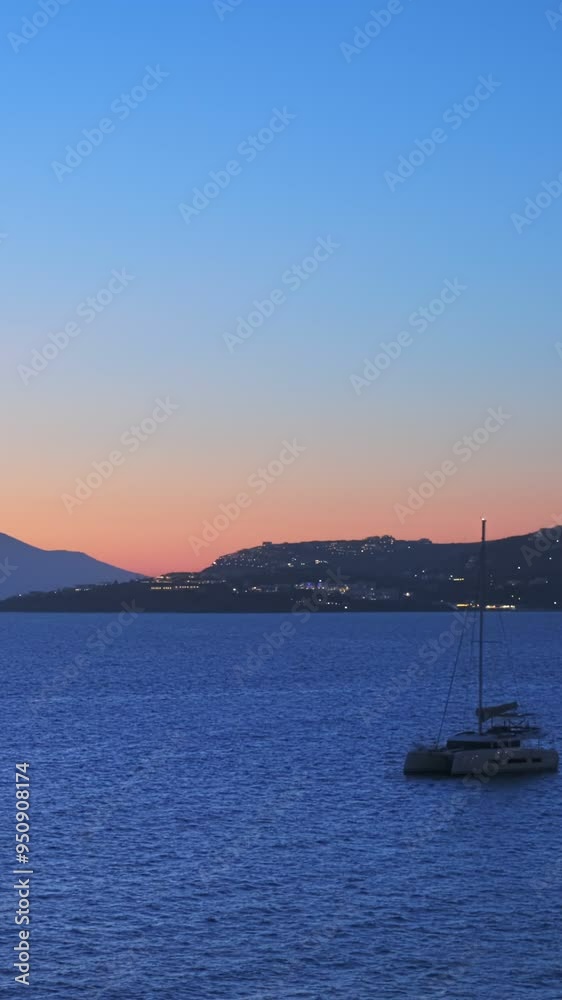 Evening in Mykonos island, Greece with yachts in the harbor and waterfront houses of Little Venice romantic spot on sunset cruise ship illuminated. Mykonos town, Greece. Horizontal camera pan