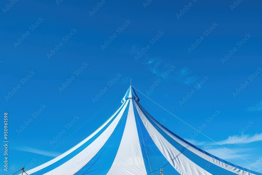 Obraz premium Blue and white striped circus tent under clear sky