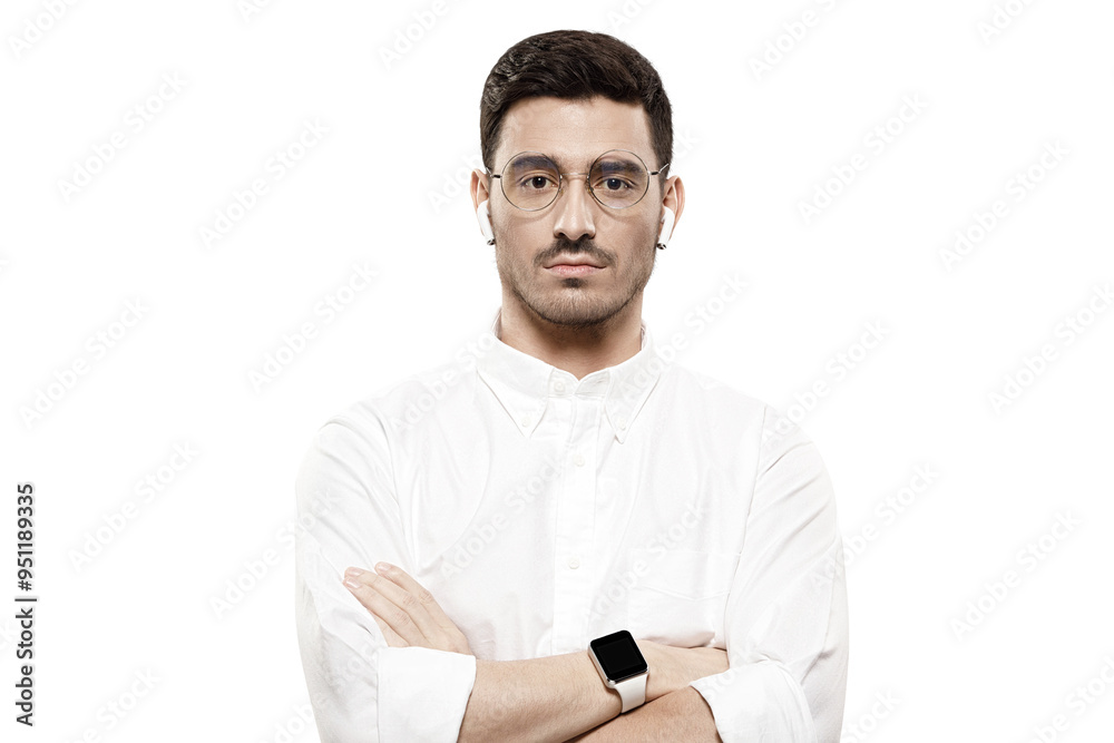 Young handsome man wearing white shirt, glasses, smartwatch and wireless earphones, standing with arms crossed Young handsome man wearing white shirt, glasses, smartwatch and wireless earphones, standing with arms crossed