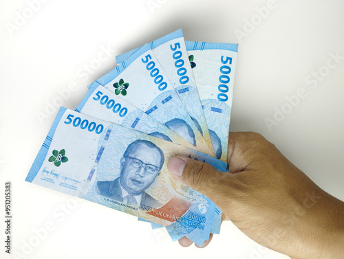 A man's hand is holding fifty thousand Indonesian banknotes. Cash payment concept. Indonesian rupiah currency (Rp. 50,000 Fifty Thousand Rupiah) on a white background