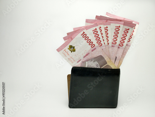 A man's hand is holding one hundred thousand Indonesian banknotes in wallet. Cash payment concept. Indonesian rupiah currency (Rp. 100,000 One Hundred Rupiah) on a white background