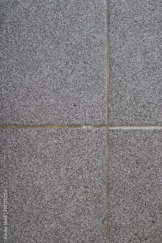 Close-up of a gray textured wall with grout lines.