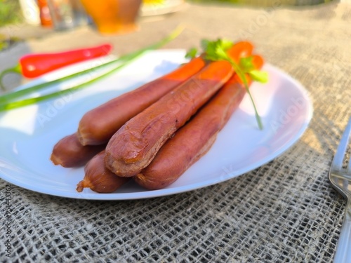 juicy fried sausages lying on a white plate High-quality photo