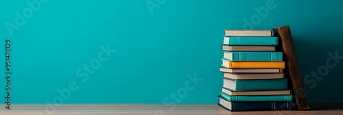 a stack of books next to a blue wall