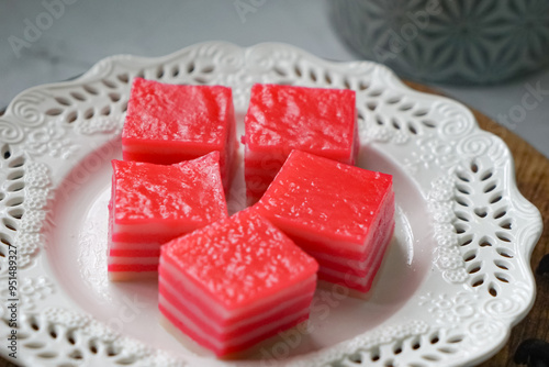 Kuih Lapis, a traditional Malay layered steamed cake and dessert, in white plates.