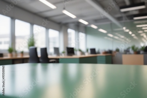 A light green blurred office interior featuring a desk with a laptop and computer  complete with a chair  monitor  keyboard