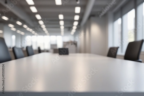 A silver blurred office interior featuring a desk with a laptop and computer, complete with a chair, monitor, keyboard, and other workspace essentials