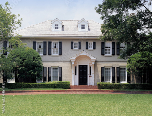 Dallas, Texas, USA - July 1, 2006: Summer view of grass and a luxury detached house with entrance door and windows