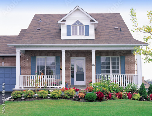 Toronto, Ontario, Canada - September 1, 2006: Summer view of a small detached house with flowers on the pot and entrance door photo