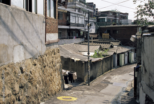 Huam-dong, Yongsan-gu, Seoul, South Korea - June 11, 2006: Summer view of alley and stonewall with town house and old detached house at Haebangchon Village photo