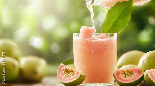 Guava juice being poured into a glass with guava chunks and a tropical leaf photo