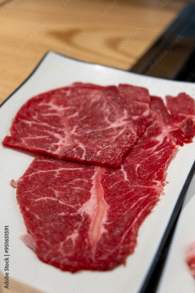 Korean Style Barbecue on plate in front of stainless grill. BBQ rare meat with soft focus Korean Style Barbecue on plate in front of stainless grill. BBQ rare meat with soft focus