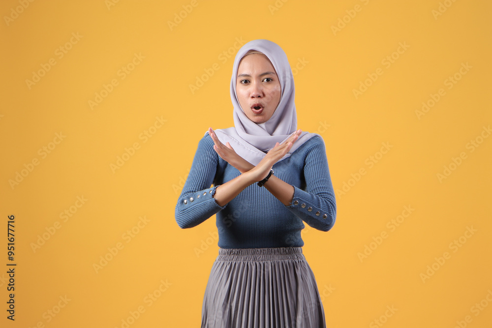 asian indonesian muslim woman showing X sign no hand gesture on isolated yellow background asian indonesian muslim woman showing X sign no hand gesture on isolated yellow background
