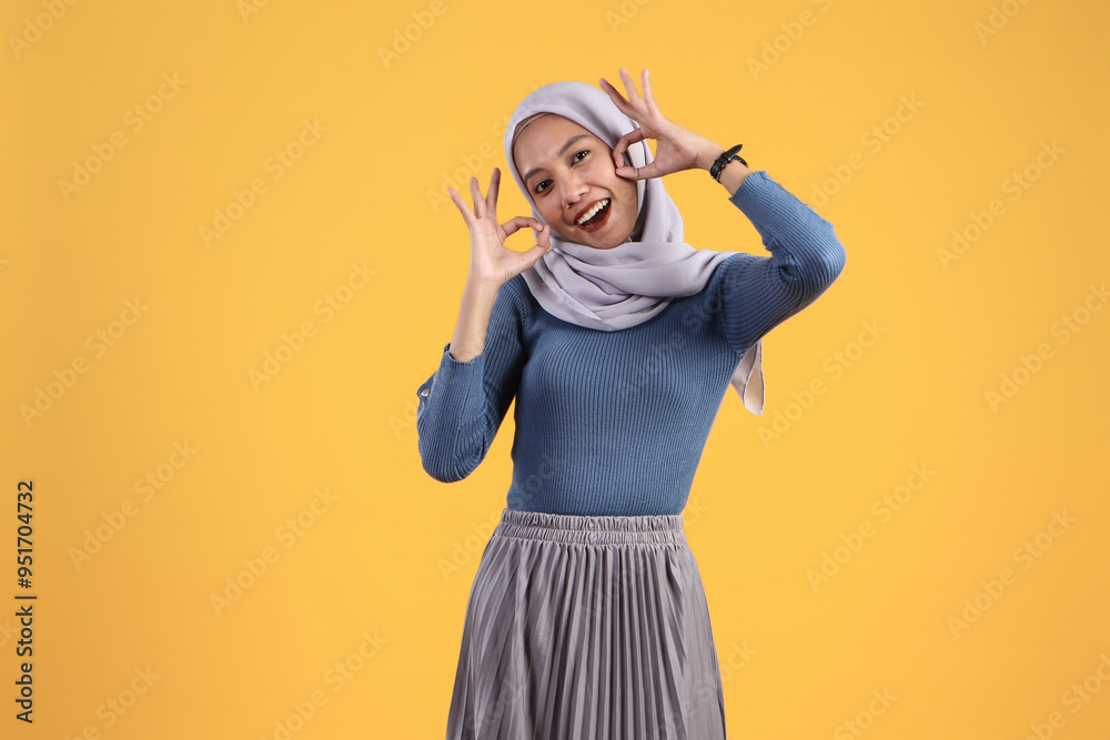happy asian indonesian muslim woman giving ok finger gesture on isolated yellow background happy asian indonesian muslim woman giving ok finger gesture on isolated yellow background