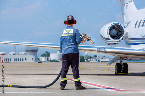 Sustainable Aviation Fuel (SAF) Technician refueling private jet with SAF at the airport.
