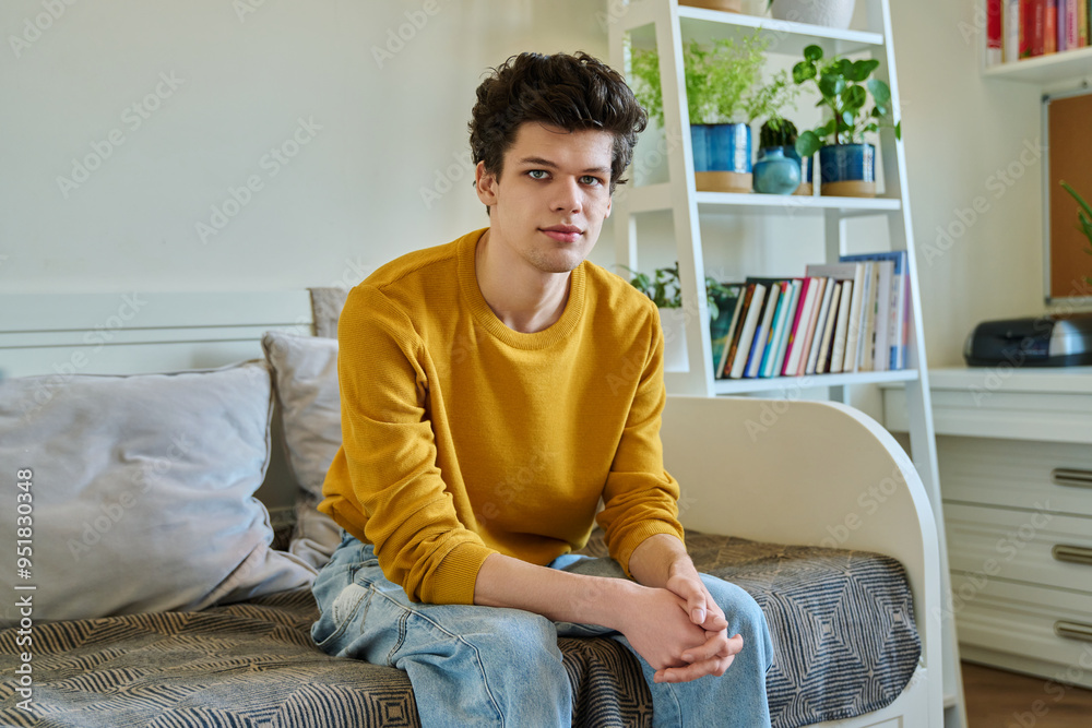 Portrait of handsome guy looking at camera, sitting on couch at home Portrait of handsome guy looking at camera, sitting on couch at home