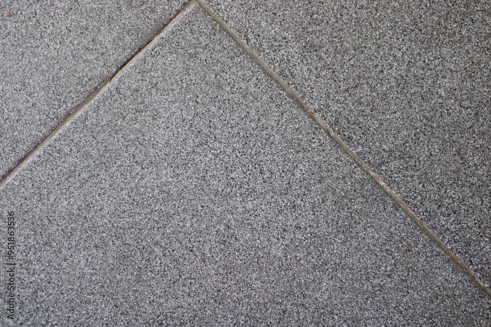 Fototapeta premium Close-up of grey tile floor with grout lines.