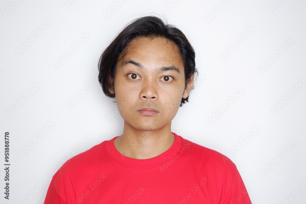 Portrait of a longish, handsome Indonesian man wearing plain red clothes with random expressions isolated on white background Portrait of a longish, handsome Indonesian man wearing plain red clothes with random expressions isolated on white background
