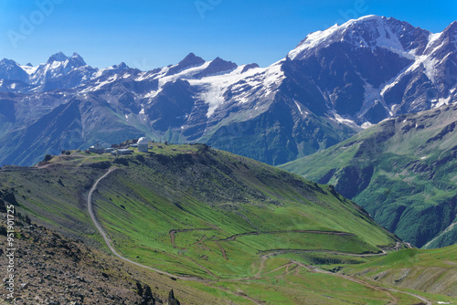 panoramic mountain landscape with green highland valley, observatory in the distance and mountain peaks in the background photo