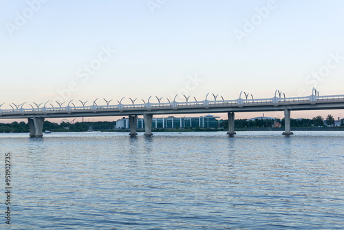 Evening cityscape with automobile bridge over river photo