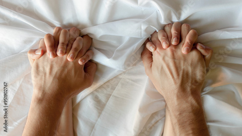 couple in love holding hands tightly while lying together in bed. photo