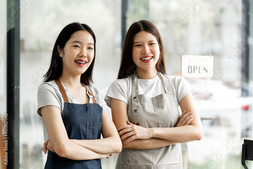 Small startup business owner concept. two successful young baristas women standing in bar counter in cafe.