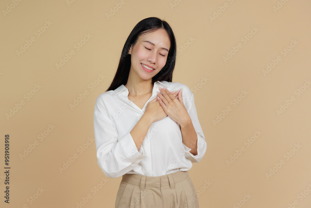 Grateful Woman with Hand on Heart, Expressing Thanks, Beige Background Grateful Woman with Hand on Heart, Expressing Thanks, Beige Background
