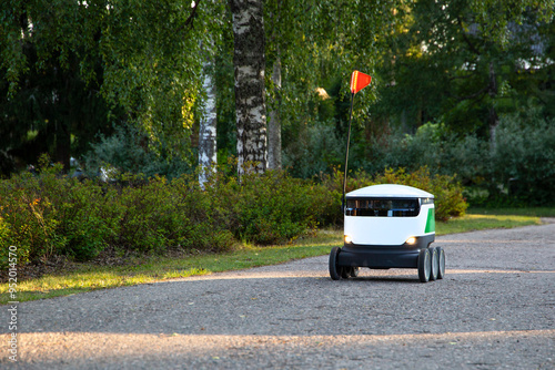 A delivery robot on wheels completes a home delivery from the grocery store. The self-driving courier navigates traffic on the road. Efficient shipping ensures quick takeaway service.