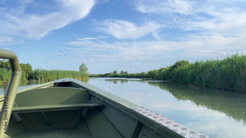 Boat tour on the Italian River. Scene features a variety of plants thriving at the water's edge, highlighting the region's rich biodiversity