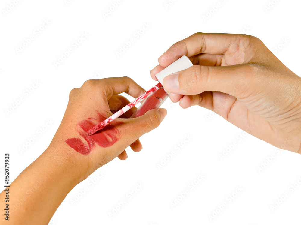 A woman's hand is trying to apply a cosmetic product lipstick on her hand, isolated on white background and close up shot. A woman's hand is trying to apply a cosmetic product lipstick on her hand, isolated on white background and close up shot.