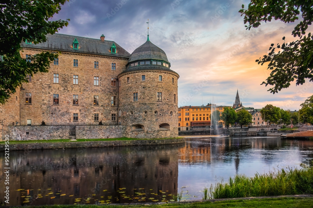 Medieval Orebro Castle is a fortification surrounded by Svartan river in sunset, light . Tourist atraction and history entusiast destination. Sweden. Copy space Medieval Orebro Castle is a fortification surrounded by Svartan river in sunset, light . Tourist atraction and history entusiast destination. Sweden. Copy space