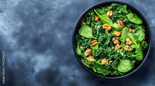 A fresh and nutritious salad with green kale, spinach, and walnuts, beautifully arranged in a modern black bowl.