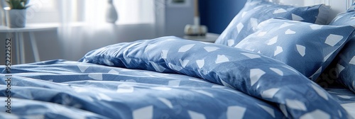 Soft morning light illuminates a peaceful bedroom featuring a cozy blue and white patterned bedspread and pillows